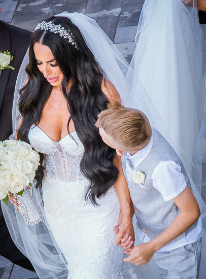 Bride and child holding hands at wedding.