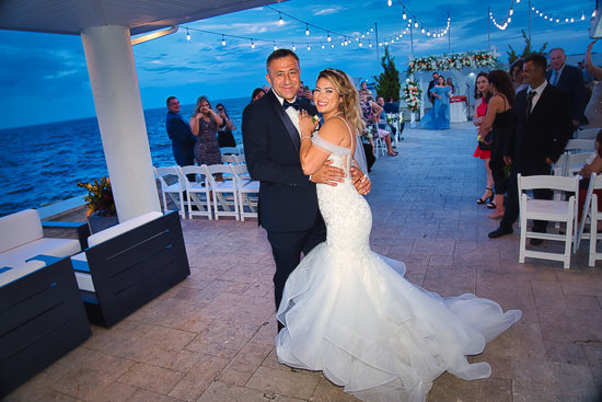 Bride and groom pose at their outdoor wedding reception.