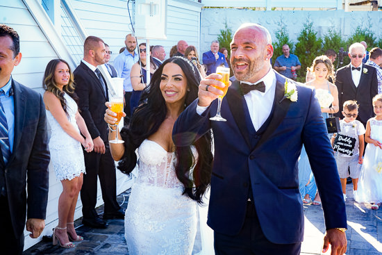 Bride and groom toast at their outdoor wedding celebration.