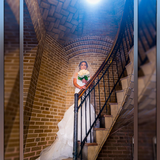 Bride on brick staircase with bouquet.