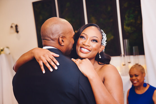 Bride smiles during first dance with groom.