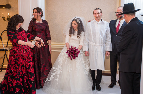 Jewish wedding celebration with bride, groom, and guests.