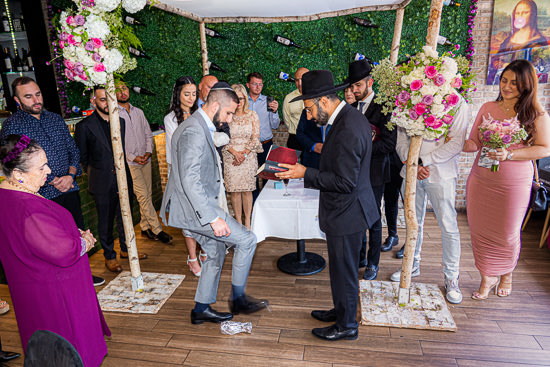 Jewish wedding ceremony with groom breaking glass.