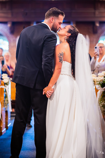 Newlyweds share a kiss at their wedding ceremony.