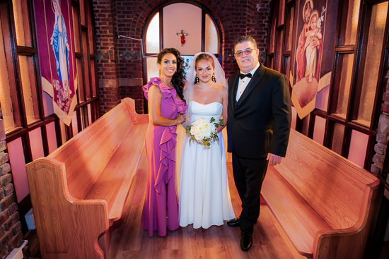 Wedding portrait in church with bride, mother, and father.