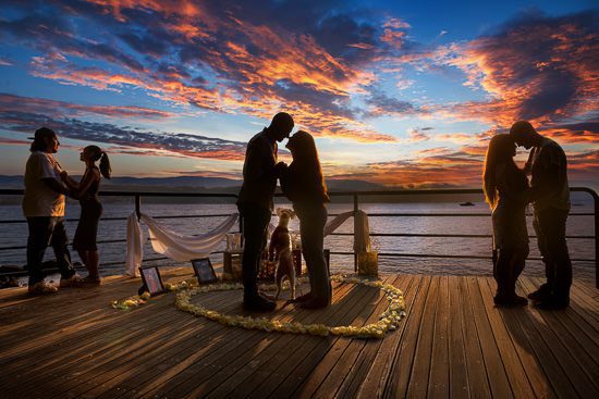 Couple's romantic proposal at sunset.